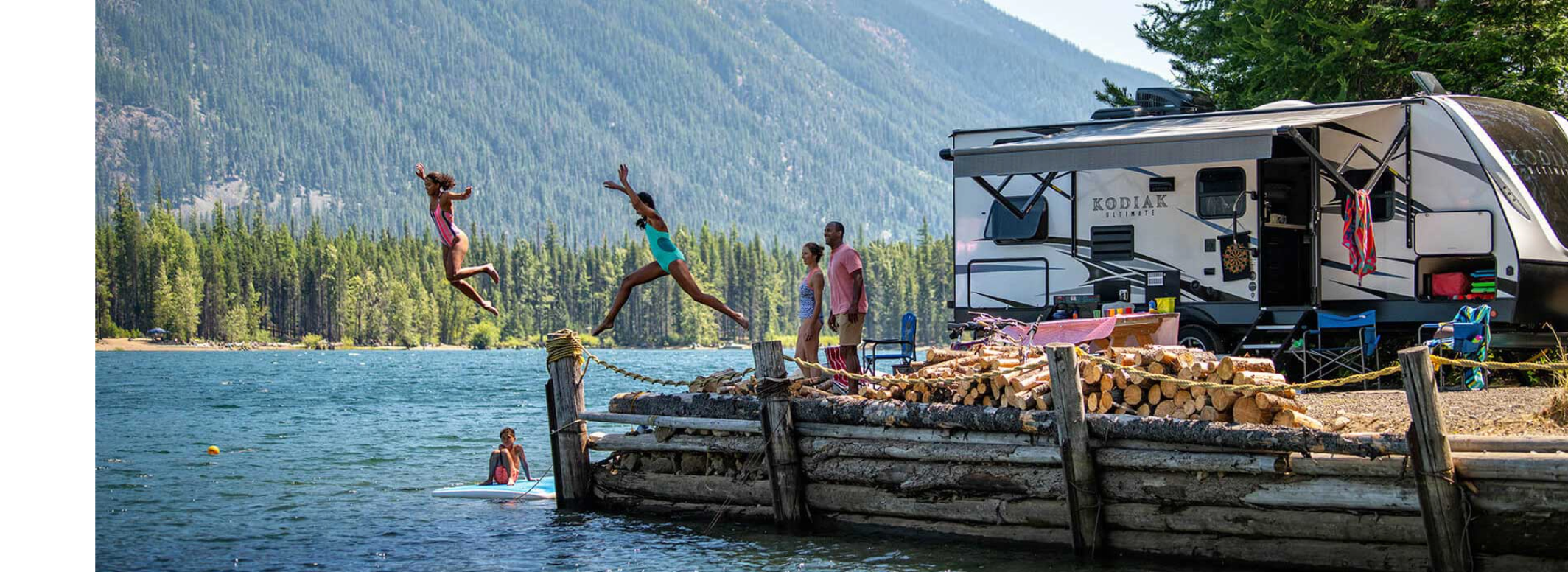Kodiak RV near lake with kids jumping into lake
